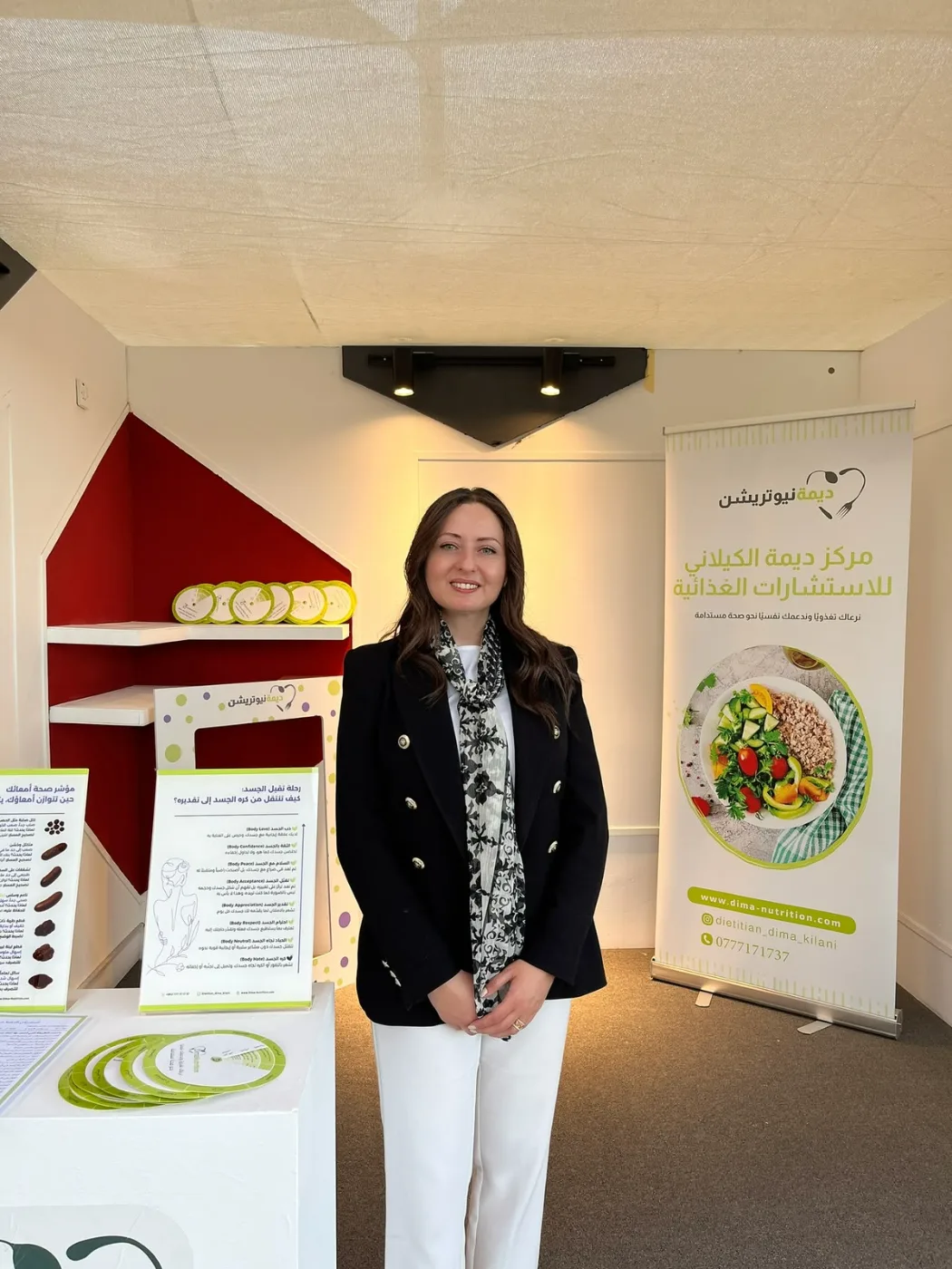 مشاركة بجانب ركن توعوي للتغذية في فعالية للتوعية بسرطان الثدي